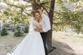 Wedding portrait. A groom in a black suit and a blonde bride in a dress and sneakers Royalty Free Stock Photo