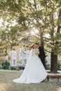 Wedding portrait. A groom in a black suit and a blonde bride in a dress and sneakers Royalty Free Stock Photo