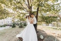 Wedding portrait. A groom in a black suit and a blonde bride in a dress and sneakers Royalty Free Stock Photo