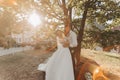 Wedding portrait. A groom in a black suit and a blonde bride in a dress and sneakers Royalty Free Stock Photo