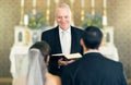 Wedding, priest and couple at the altar saying vows while getting married in a church for commitment, love and care Royalty Free Stock Photo