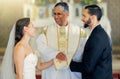 Wedding, priest and couple holding hands in church for a christian marriage oath and faithful commitment. Trust, bride Royalty Free Stock Photo