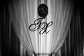 Wedding reception decoration: initials and icon on white curtain Royalty Free Stock Photo