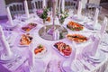 Wedding reception dinner. Round table served with flowers, shiny candles and appetizer food. Holiday banquet menu Royalty Free Stock Photo