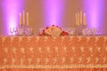 Wedding reception or fine dining table setup with embroidered organza tablecloth, crystal candle holders and a floral arrangement Royalty Free Stock Photo