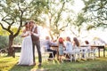 Bride and groom clinking glasses at wedding reception outside in the backyard. Royalty Free Stock Photo