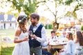 Bride and groom clinking glasses at wedding reception outside in the backyard. Royalty Free Stock Photo