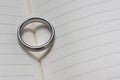 Wedding Ring Band on Book with Heart Shadow Close Up Angled View Royalty Free Stock Photo