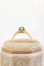 Wedding ring with emerald green gemstone in beige velvet jewelry box Royalty Free Stock Photo
