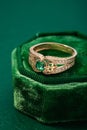 Wedding ring with emerald green gemstone on green velvet jewelry box Royalty Free Stock Photo