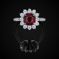 Wedding ring front view with red ruby and white diamonds on black background with reflection. Jewellery with gemstone