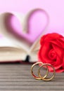 Wedding ring with pages of book curved heart shape with red rose Royalty Free Stock Photo