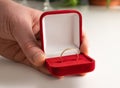 Wedding ring red box surrounded by rose petals. An offer of marriage. Box with a ring in the hands of a man on a blurred Royalty Free Stock Photo