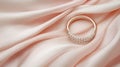 A wedding ring rests elegantly on a pink silk cloth. Royalty Free Stock Photo