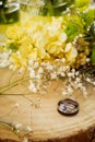 Wedding ring still life on wood with flowers