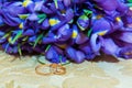 Wedding ring. Two gold vintage diamond rings and a bouquet of bride and blue flowers Royalty Free Stock Photo