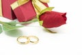 Wedding rings and artificial rose on white background Royalty Free Stock Photo