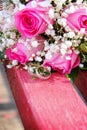 Wedding rings on the background of a wedding bouquet lie on a bench