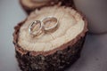 Wedding rings with beautiful carvings on the background of sawn wood and linen fabric, close-up