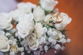 Wedding rings on beautiful white flowers bouquet. Copy space.