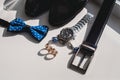 Wedding rings. Black leather shoes, watch, blue bow tie and cufflinks, on a white window sill. Royalty Free Stock Photo