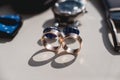 Wedding rings. Black leather shoes, watch, blue bow tie and cufflinks, on a white window sill. Royalty Free Stock Photo