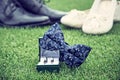 Wedding rings, bow tie and women`s and men`s shoes on grass Royalty Free Stock Photo