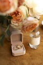Wedding rings in the box, flowers near bridal parfume bottle