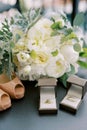 Wedding rings in boxes stand near the bride shoes and a bouquet of flowers on the table Royalty Free Stock Photo