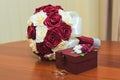 Wedding rings of the bride and groom on a Beautiful wedding bouquet of red and white roses. Wooden box for wedding rings Royalty Free Stock Photo