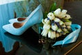 Wedding rings of the bride and groom on a Beautiful wedding bouquet of white tulips. Blue wedding shoes Royalty Free Stock Photo