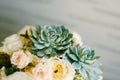 Wedding rings of the bride and groom on the echeveria flower in the bride`s wedding bouquet on a blurred background. Royalty Free Stock Photo