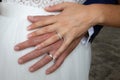 Wedding rings on bride and groom hands on marriage white dress background Royalty Free Stock Photo