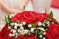 Wedding rings are on the bride`s bouquet. Wedding bouquet of red roses and white gypsophila. Wedding background for cards and Royalty Free Stock Photo