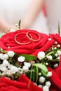 Wedding rings are on the bride`s bouquet. Wedding bouquet of red roses and white gypsophila. Wedding background for cards and Royalty Free Stock Photo