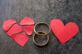 Wedding rings and broken red heart. Black background. The conce Royalty Free Stock Photo