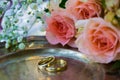 Wedding rings before the ceremony, with decorated Champagne glasses and roses