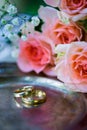 Wedding rings before the ceremony, with decorated Champagne glasses and roses