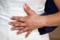 Wedding rings and couple hands fingers bride and groom in love over marriage dress background Royalty Free Stock Photo