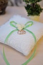 Wedding rings on a cushion with green bow Royalty Free Stock Photo