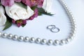 Wedding rings, flowers, beads on a white backgroun Royalty Free Stock Photo