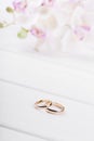 Wedding rings with flowers on white wooden table Royalty Free Stock Photo