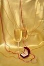 Wedding rings and glasses with sparkling wine on a golden background Royalty Free Stock Photo