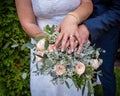 Wedding rings on the hands of the newlyweds on a bouquet Royalty Free Stock Photo