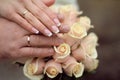 Wedding rings and Hands on roses bouquet