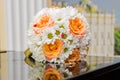 Wedding rings lie on a bouquet of orange roses and white colors. Royalty Free Stock Photo