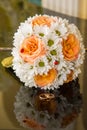 Wedding rings lie on a bouquet of orange roses and white colors. Royalty Free Stock Photo