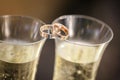 Wedding rings lie on champagne glasses Royalty Free Stock Photo