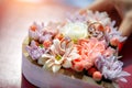 Wedding rings lie among fresh flowers in small wooden box, close up. Gold wedding rings on flower background, selective focus Royalty Free Stock Photo