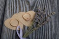 Wedding rings lie on hearts cut out of paper. Near a bunch of lavender. On brushed pine boards painted in black and white Royalty Free Stock Photo